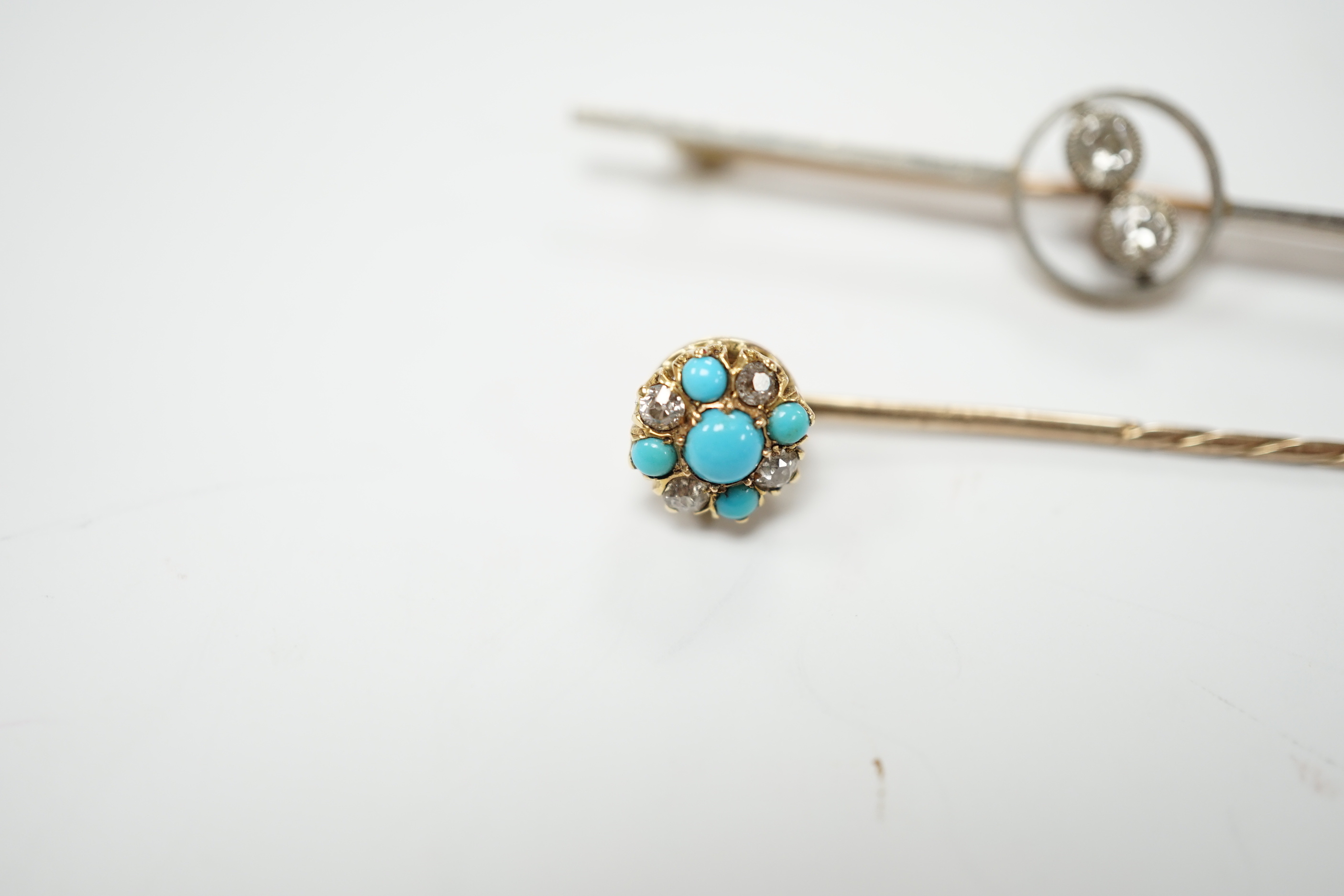 An early 20th century yellow metal, white metal and two stone diamond crossover set bar brooch, 57mm and a similar turquoise and diamond cluster set stick pin.